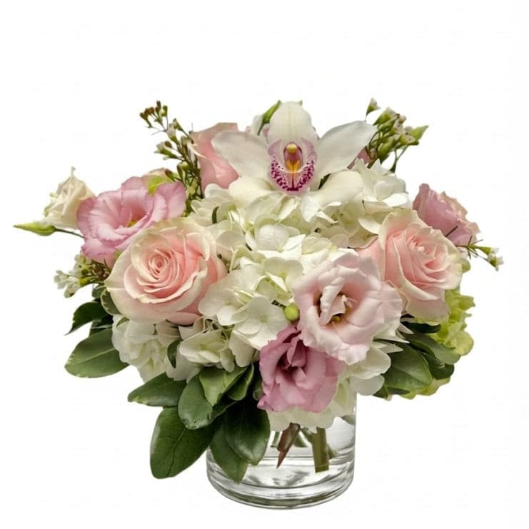 Bouquet of pink and white flowers in a clear vase on a white background