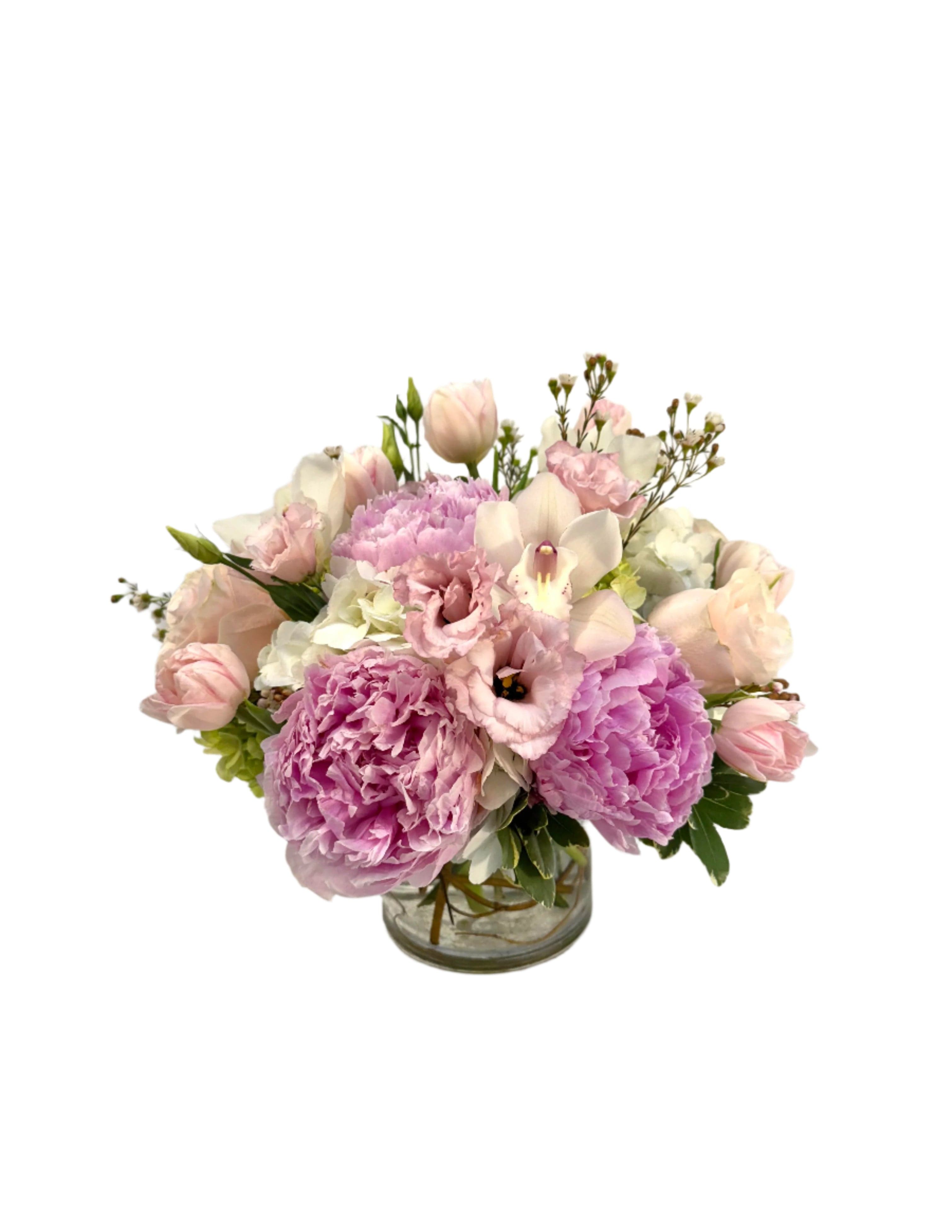 A beautiful arrangement of peonies, tulips, and delicate flowers in a glass vase for elegant decor.