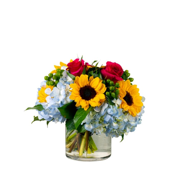 Vibrant floral arrangement featuring sunflowers, roses, and hydrangeas in a glass vase, perfect for any occasion.