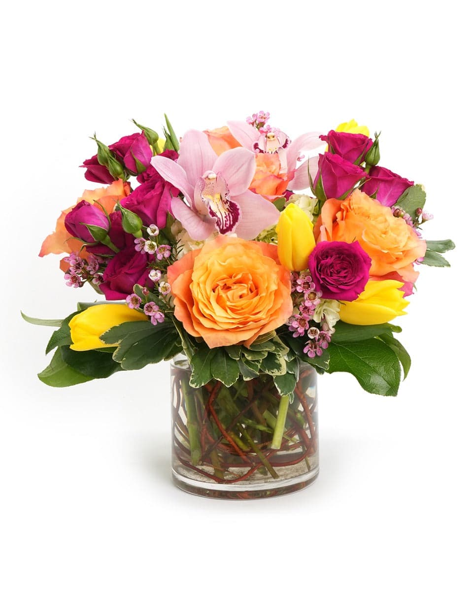 Vibrant mixed flower bouquet featuring roses, orchids, and tulips in a stylish glass vase. Perfect for any occasion.