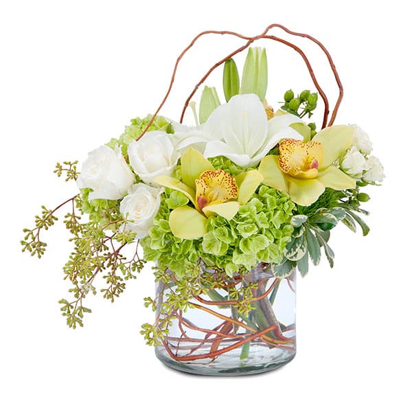 Elegant floral arrangement featuring white roses, vibrant orchids, and lush greenery in a stylish glass vase.