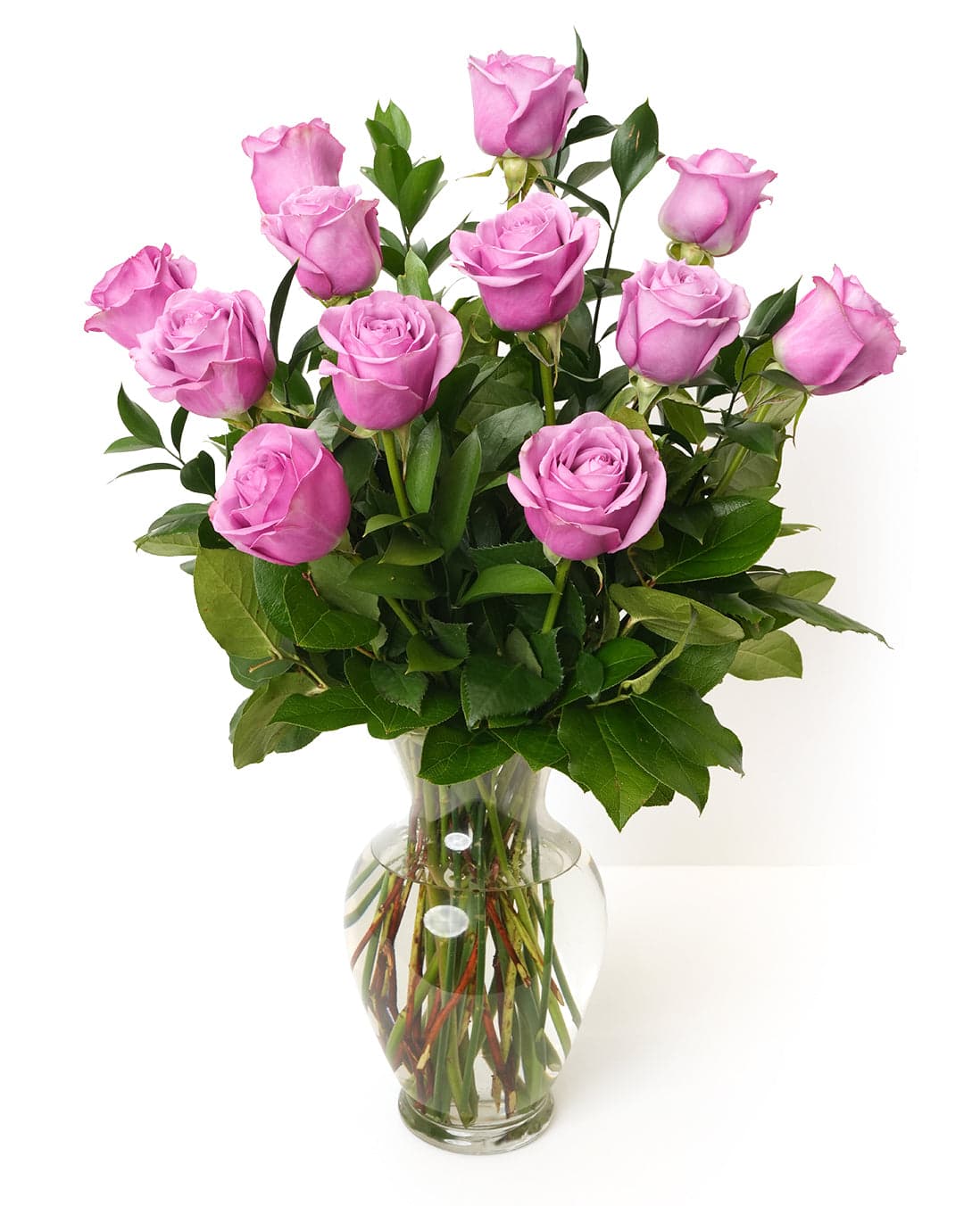 A stunning bouquet of twelve lavender roses arranged in a clear glass vase, perfect for any occasion.